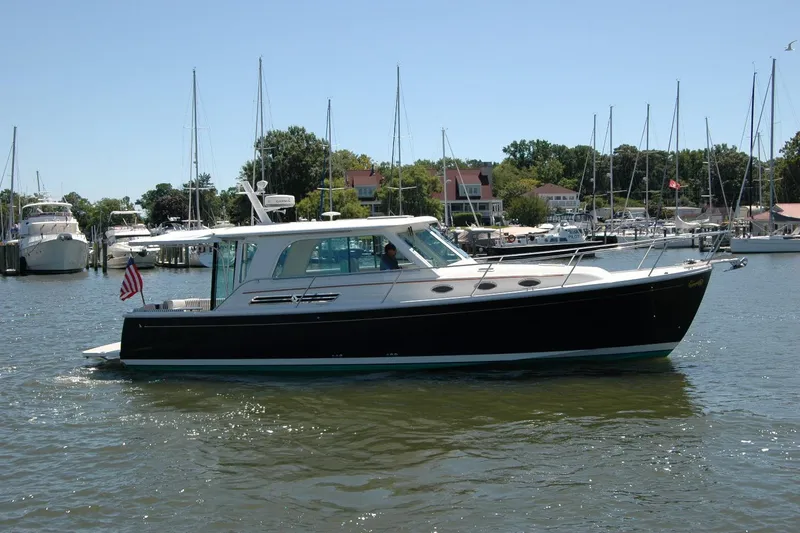 Slide: The Image of 2014 Back Cove 37 yacht cruising in a marina with sailboats in the background. - 10