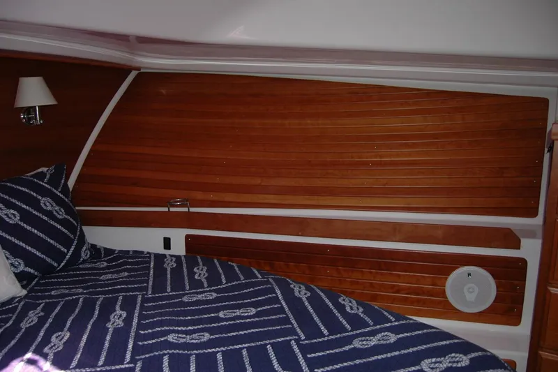 Slide: The Image of 2014 Back Cove 37 interior cabin with wood paneling and nautical-themed bedding. - 103