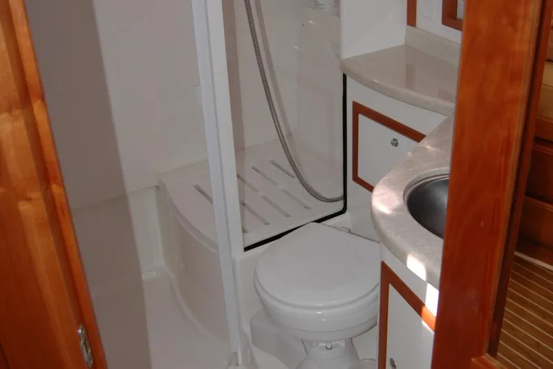 Slide: The Image of 2014 Back Cove 37 yacht bathroom with shower, sink, and wooden cabinetry. - 111