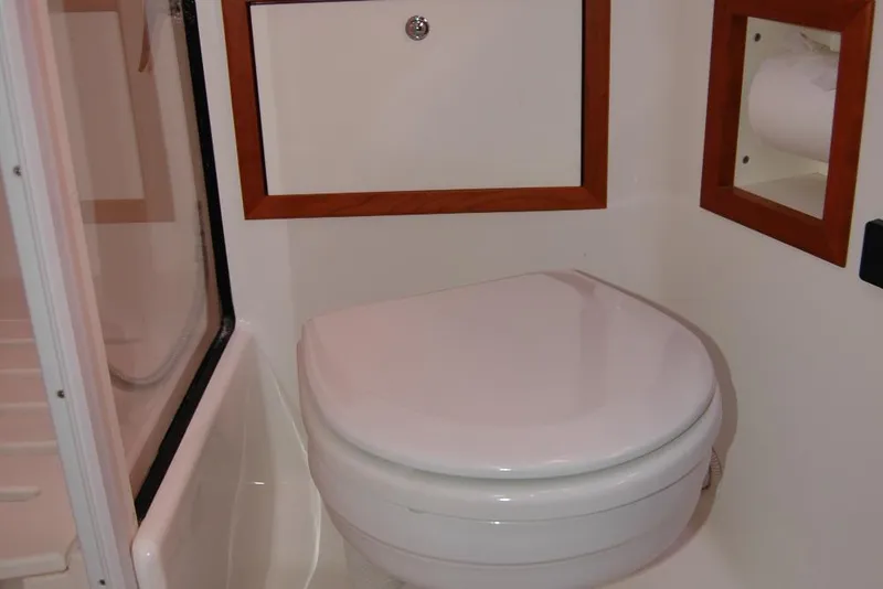 Slide: The Image of 2014 Back Cove 37 yacht bathroom with toilet and wooden accents. - 113
