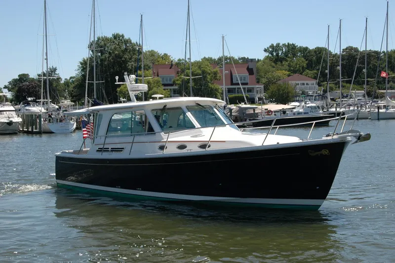 Slide: The Image of 2014 Back Cove 37 boat cruising in a marina with sailboats and waterfront homes. - 12