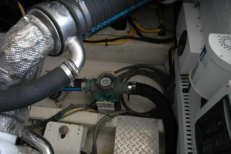Slide: The Image of Engine compartment of a 2014 Back Cove 37 boat, showing hoses and mechanical components. - 125