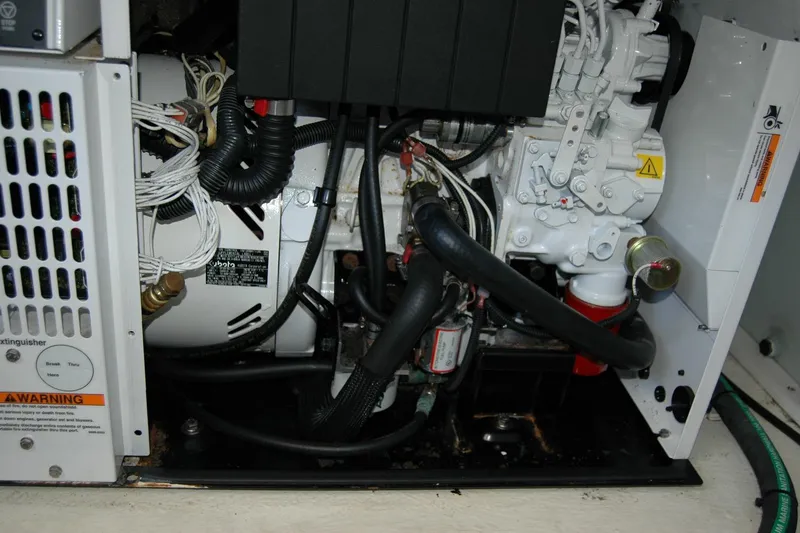 Slide: The Image of Engine compartment of a 2014 Back Cove 37 boat, showcasing mechanical components and wiring. - 129