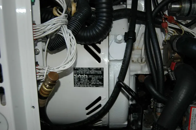 Slide: The Image of Engine compartment of a 2014 Back Cove 37 boat featuring Kubota components. - 130