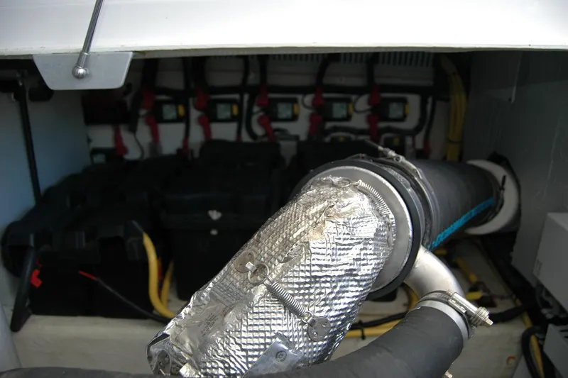 Slide: The Image of Engine compartment of a 2014 Back Cove 37 boat, showing exhaust and battery setup. - 135