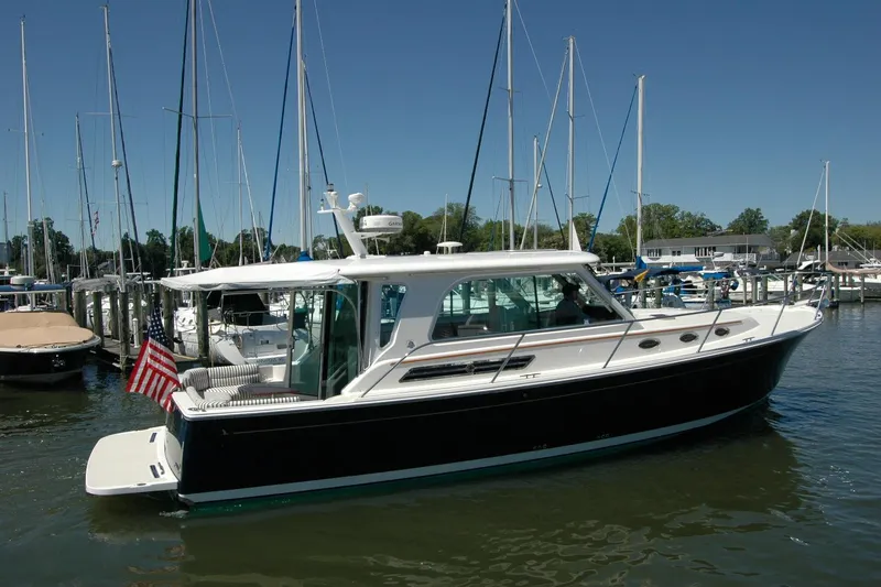 Slide: The Image of 2014 Back Cove 37 yacht docked in a marina under clear blue skies. - 14