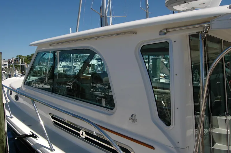 Slide: The Image of 2014 Back Cove 37 yacht docked, showcasing sleek windows and polished railings. - 19