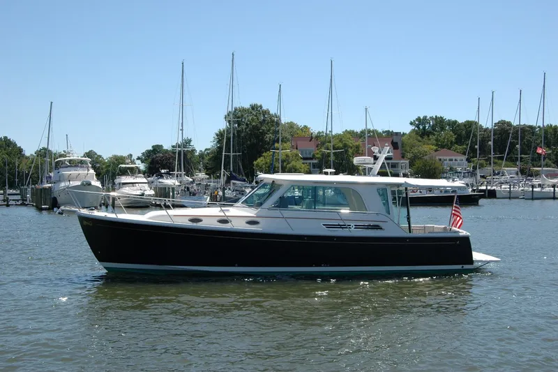 Slide: The Image of 2014 Back Cove 37 yacht docked in a marina with sailboats in the background. - 2