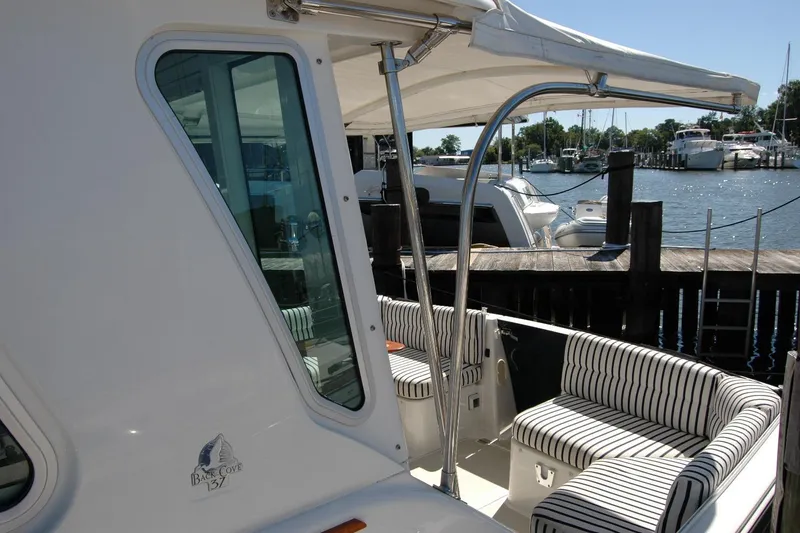 Slide: The Image of 2014 Back Cove 37 yacht with striped seating, docked at a marina. - 23