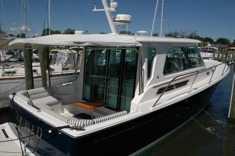 Slide: The Image of 2014 Back Cove 37 yacht docked, featuring sleek design and spacious seating area. - 24