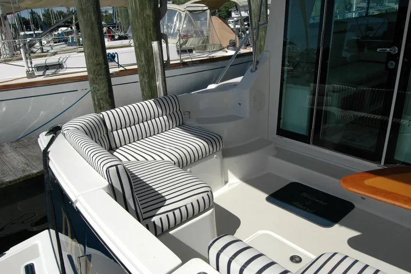 Slide: The Image of 2014 Back Cove 37 yacht with striped seating and wooden table in the cockpit area. - 28
