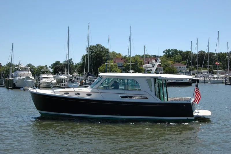 Slide: The Image of 2014 Back Cove 37 yacht docked in a marina, surrounded by sailboats. - 3