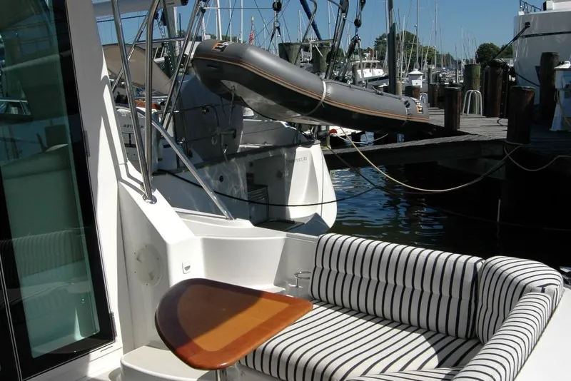 Slide: The Image of 2014 Back Cove 37 yacht with striped seating and docked inflatable boat. - 33