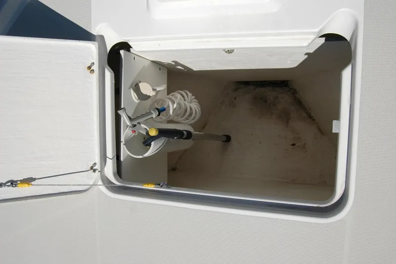 Slide: The Image of Storage compartment with hose and nozzle on a 2014 Back Cove 37 boat. - 37