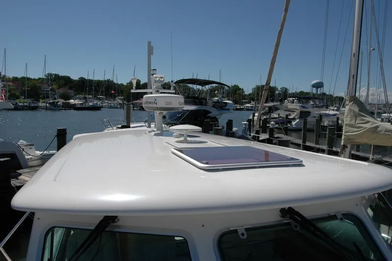 Slide: The Image of 2014 Back Cove 37 yacht docked at marina, featuring Garmin radar and clear sky. - 38