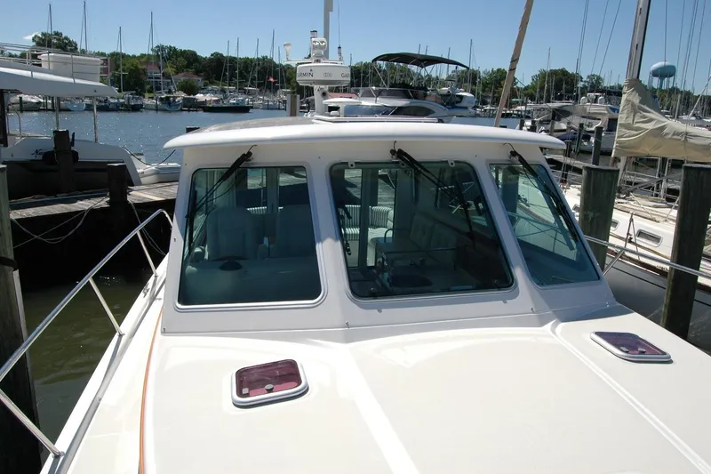 Slide: The Image of 2014 Back Cove 37 boat docked at a marina, showcasing its cabin and windshield. - 39