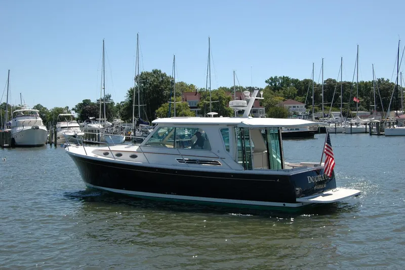 Slide: The Image of 2014 Back Cove 37 boat docked in a marina with sailboats in the background. - 4