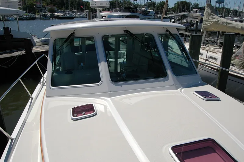 Slide: The Image of 2014 Back Cove 37 boat docked at marina, showcasing front deck and windows. - 40