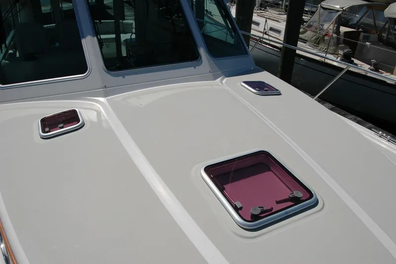 Slide: The Image of 2014 Back Cove 37 boat deck with purple hatches, docked at marina. - 41
