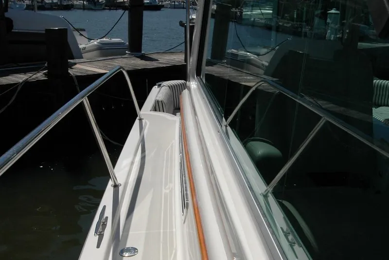 Slide: The Image of 2014 Back Cove 37 yacht docked, showcasing sleek railing and reflective windows. - 42