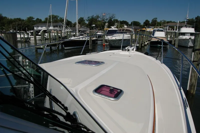 Slide: The Image of 2014 Back Cove 37 yacht docked in a marina, showcasing its sleek deck design. - 44
