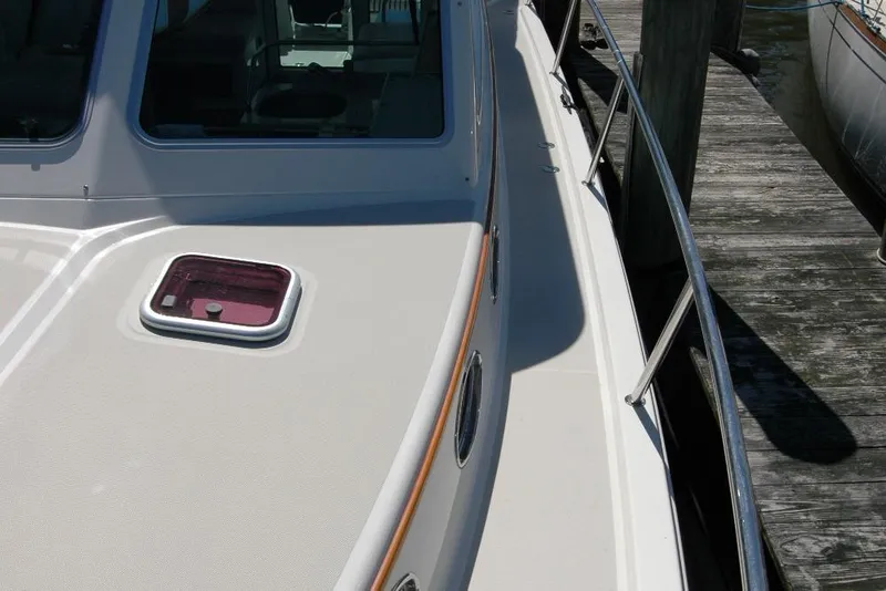Slide: The Image of 2014 Back Cove 37 boat deck with railing and hatch, docked at a wooden pier. - 47