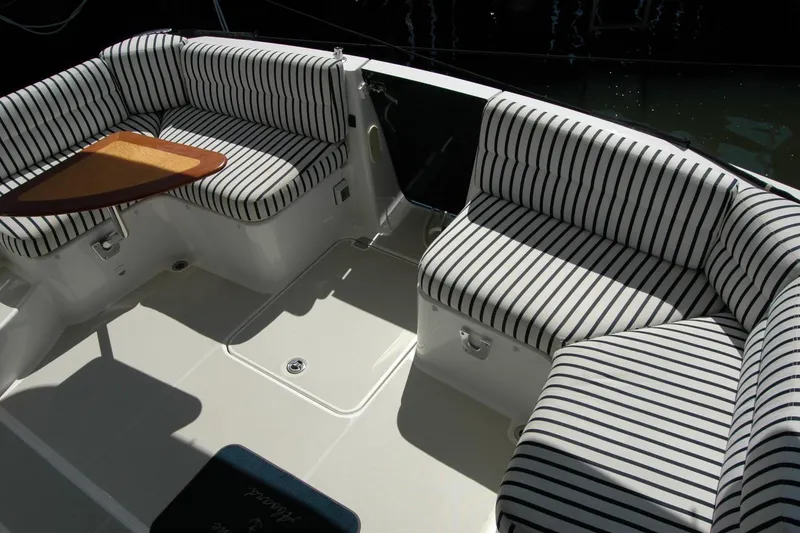 Slide: The Image of 2014 Back Cove 37 boat interior with striped seating and wooden table. - 50
