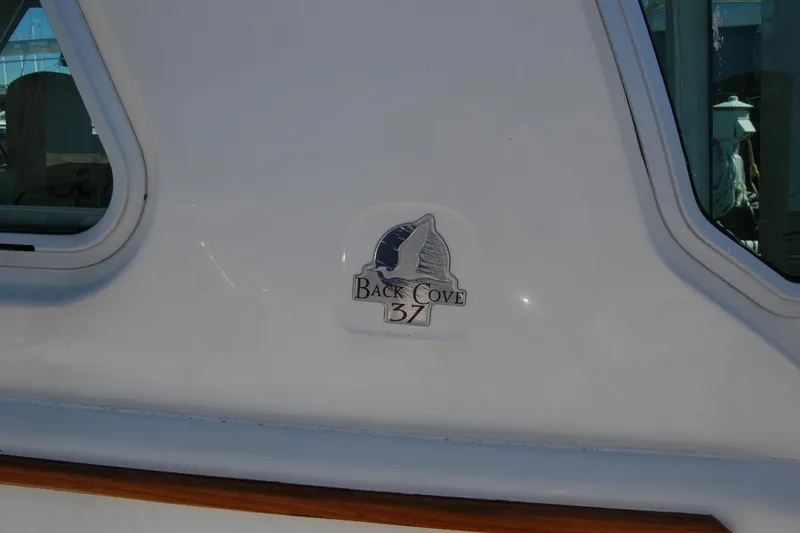 Slide: The Image of 2014 Back Cove 37 boat logo on white exterior near window. - 51