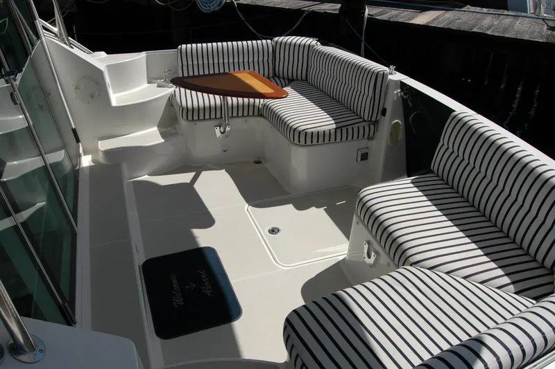 Slide: The Image of 2014 Back Cove 37 boat interior with striped seating and a small wooden table. - 52