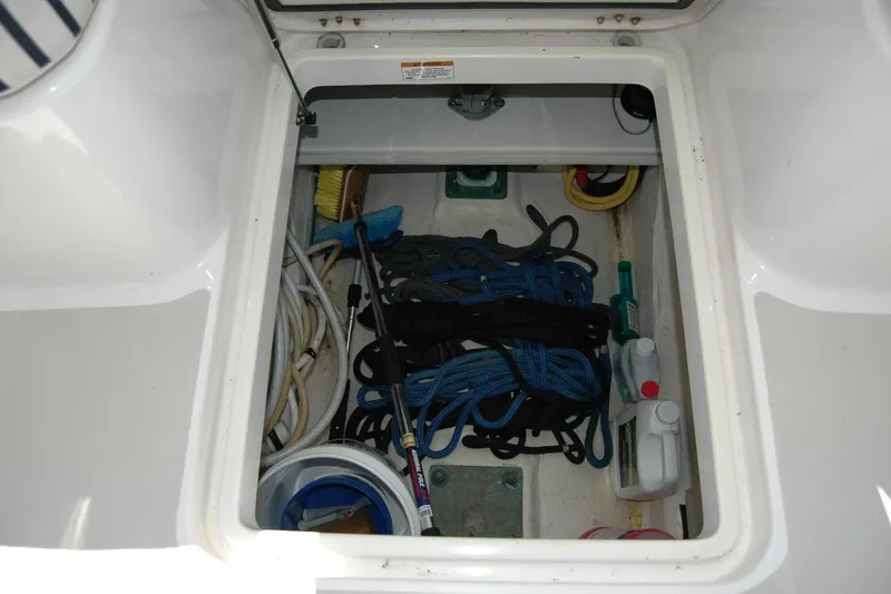 Slide: The Image of Storage compartment on a 2014 Back Cove 37 boat with ropes and cleaning supplies. - 55