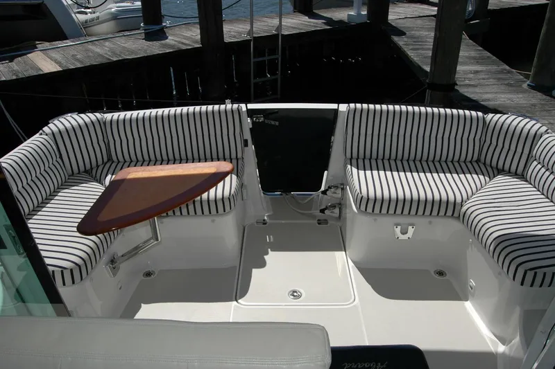 Slide: The Image of 2014 Back Cove 37 boat cockpit with striped seating and wooden table. - 56