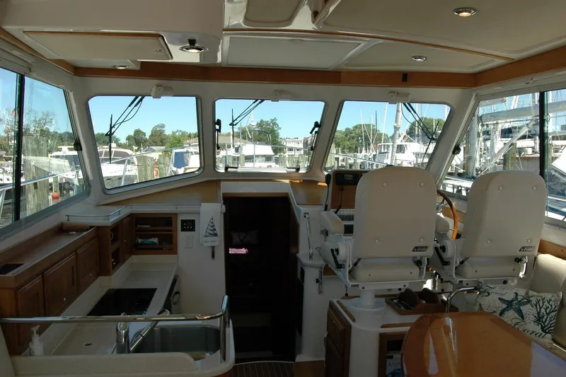 Slide: The Image of Interior of 2014 Back Cove 37 yacht with helm, seating, and windows overlooking marina. - 61