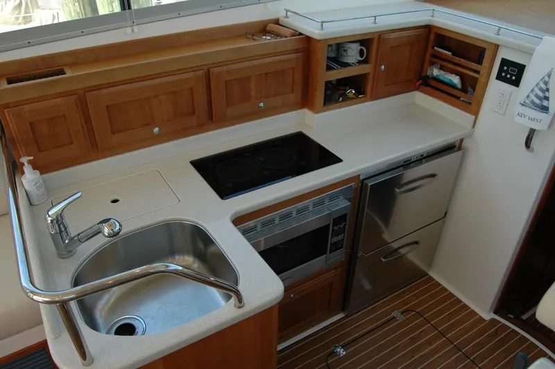 Slide: The Image of 2014 Back Cove 37 yacht kitchen with sink, stove, and wooden cabinetry. - 68