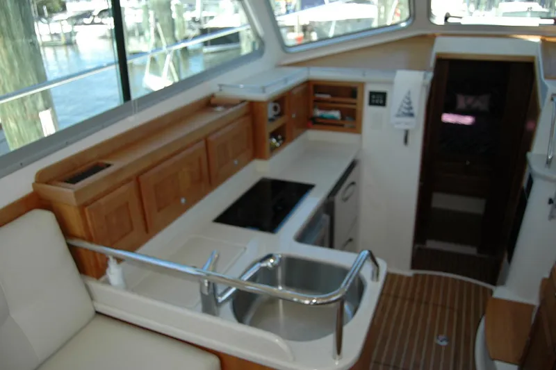 Slide: The Image of Interior of 2014 Back Cove 37 yacht, featuring a compact kitchen with wooden cabinetry. - 70