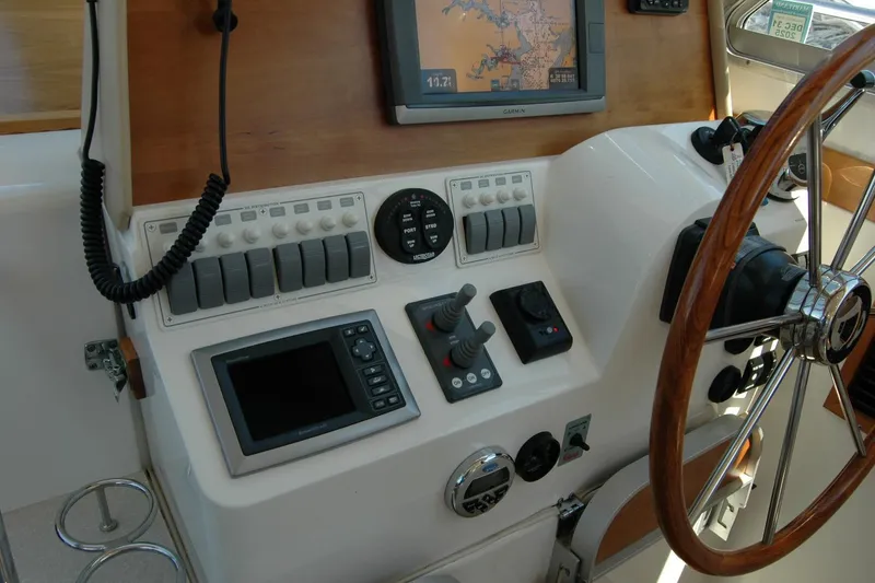 Slide: The Image of 2014 Back Cove 37 helm with navigation controls and wooden steering wheel. - 74