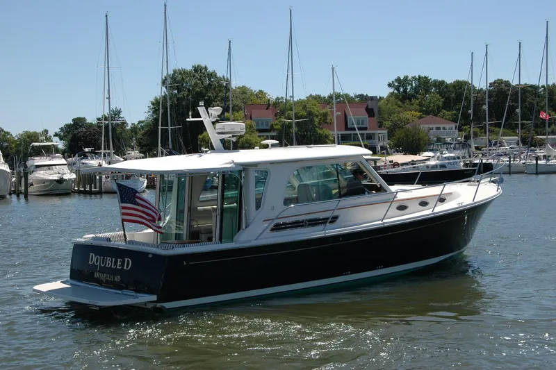 Slide: The Image of 2014 Back Cove 37 boat in marina, American flag, sunny day, surrounded by other boats. - 8