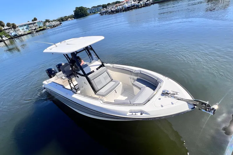 Slide: The Image of 2023 Boston Whaler 230 Outrage boat on calm water, featuring sleek design and spacious seating. - 10