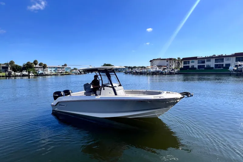 Slide: The Image of 2023 Boston Whaler 230 Outrage boat on calm water, clear blue sky background. - 4