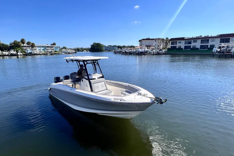 Slide: The Image of 2023 Boston Whaler 230 Outrage boat on calm water near waterfront buildings. - 5