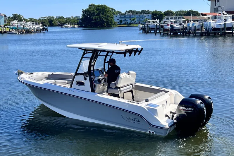 Slide: The Image of 2023 Boston Whaler 230 Outrage boat on calm water, featuring dual Mercury engines. - 8
