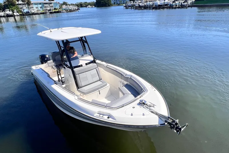 Slide: The Image of 2023 Boston Whaler 230 Outrage boat on calm water, featuring sleek design and spacious seating. - 9