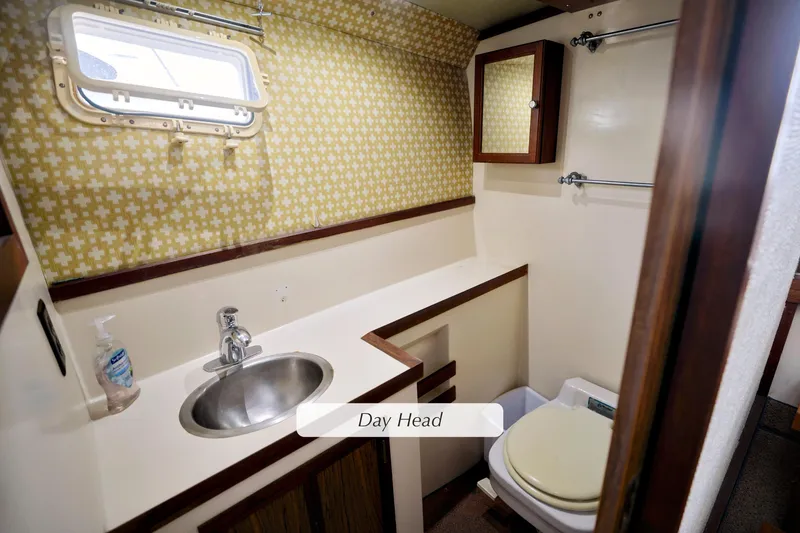 Slide: The Image of 1980 Pacifica 41 Sportfisher bathroom with sink, toilet, and patterned wallpaper. - 16