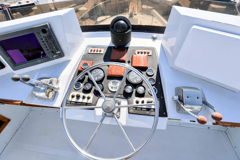 Slide: The Image of Control panel of a 1980 Pacifica 41 Sportfisher boat with steering wheel and navigation instruments. - 4