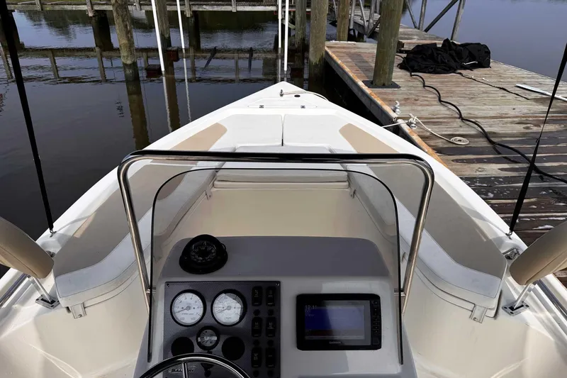 Slide: The Image of 2021 Bulls Bay 2200 boat interior with dashboard and dock view. - 25