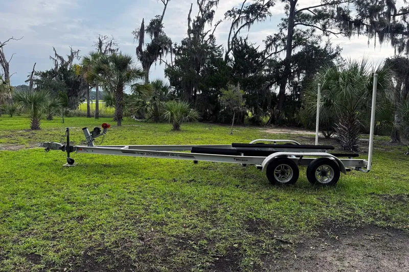 Slide: The Image of Boat trailer for 2021 Bulls Bay 2200 on grassy landscape with trees. - 27