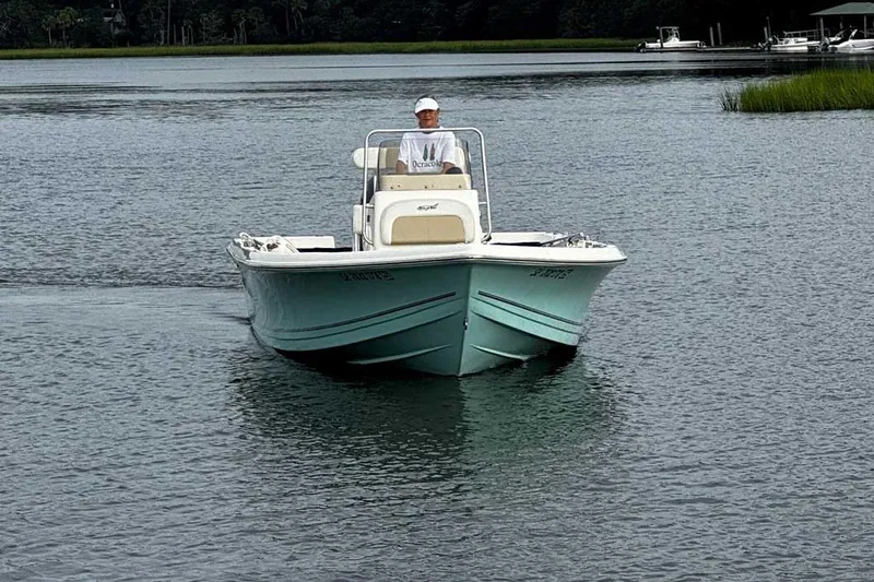 Slide: The Image of 2021 Bulls Bay 2200 boat cruising on a calm lake with a person onboard. - 6