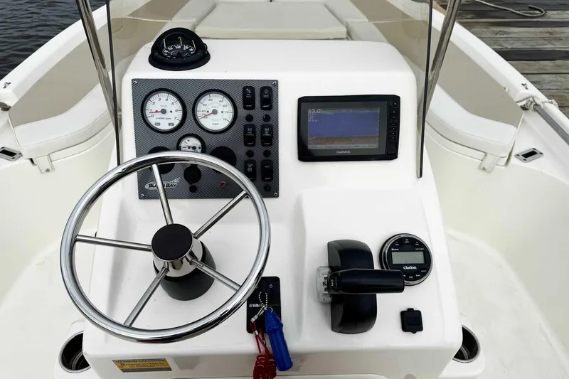 Slide: The Image of 2021 Bulls Bay 2200 boat dashboard with steering wheel, gauges, and Garmin display. - 8
