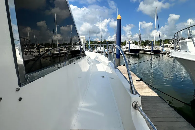 Slide: The Image of Prima 52 Seahorse yacht docked at marina, reflecting blue sky and clouds, 2001 model. - 11