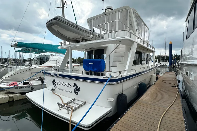 Slide: The Image of 2001 Prima 52 Seahorse yacht docked at marina, overcast sky, named "Pegasus." - 16