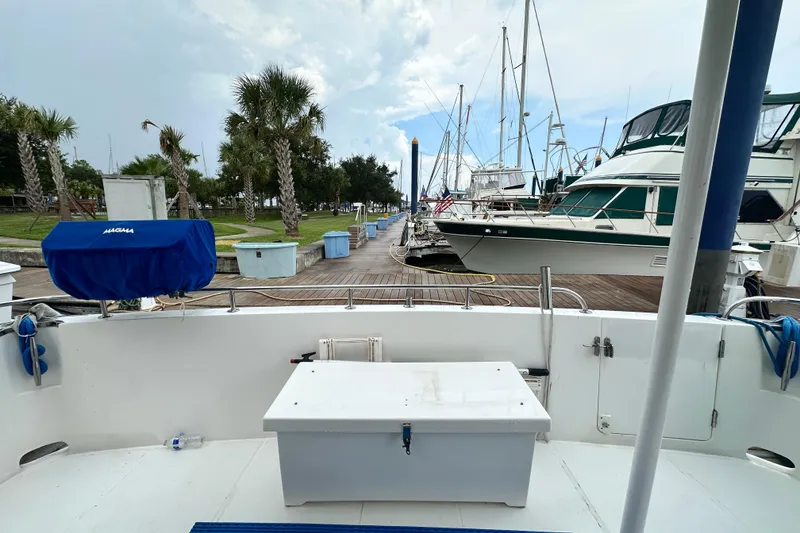 Slide: The Image of Docked Prima 52 Seahorse yacht, 2001 model, with marina and palm trees in background. - 18